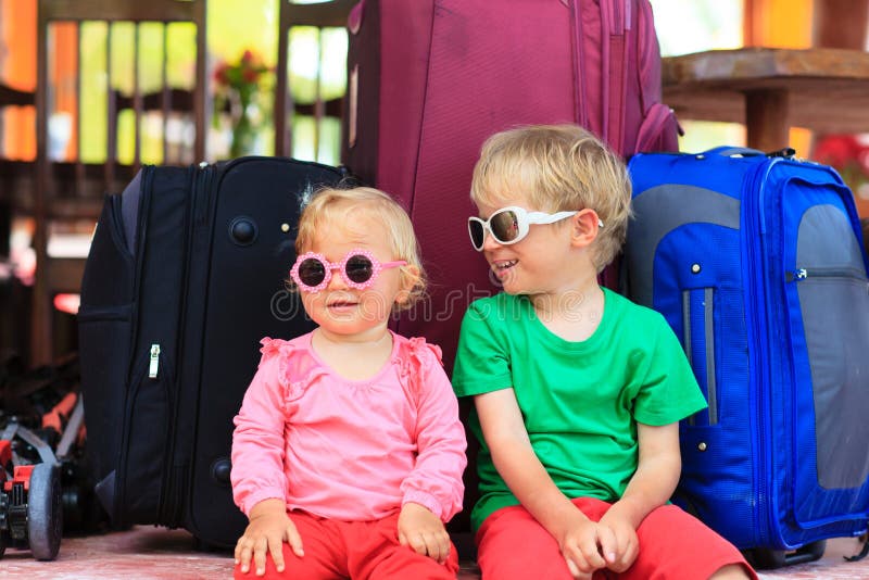 Bambini che si siedono sulle valigie pronte a viaggiare fotografie stock Bambini che si siedono sulle valigie pronte a viaggiare fotografie stock
