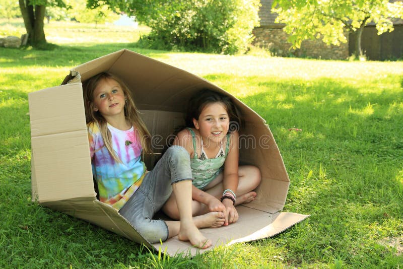 Bambini che si siedono in una scatola immagini stock Bambini che si siedono in una scatola immagini stock