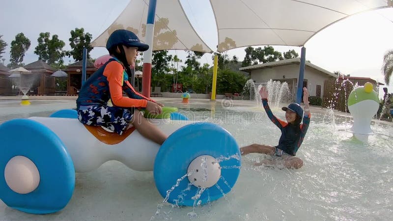 Bambini che viaggiano su carrelli d'acqua che spruzzano acqua nell'acquaacqua