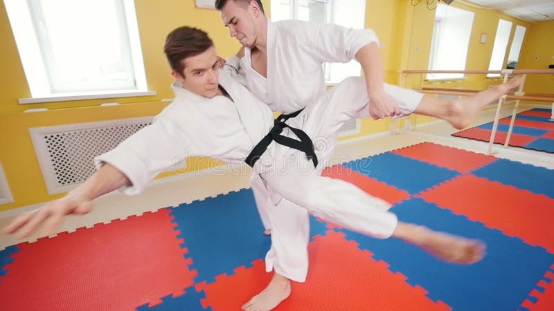 bambini cinesi di KONGFU Due uomini atletici che preparano le loro abilit? di aikidi nello studio Colpire l'oppositore nel bracci