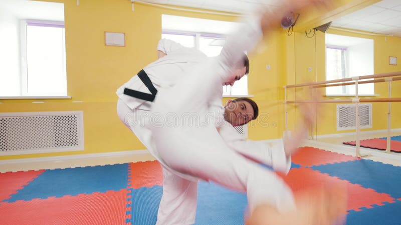 bambini cinesi di KONGFU Due uomini atletici che preparano le loro abilit? di aikidi nello studio Lancio dell'oppositore sul pavi