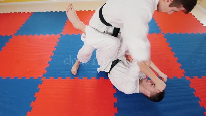 bambini cinesi di KONGFU Due uomini atletici che preparano le loro abilità di aikidi Proteggendo da un colpo della gamba e gettar
