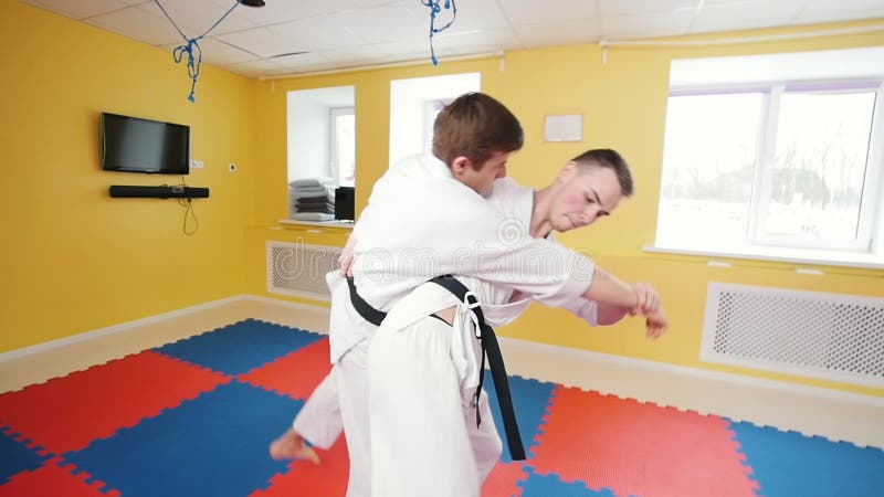 bambini cinesi di KONGFU Due uomini atletici che preparano le loro abilità di aikidi in studio luminoso Schiva il colpo ed il lan