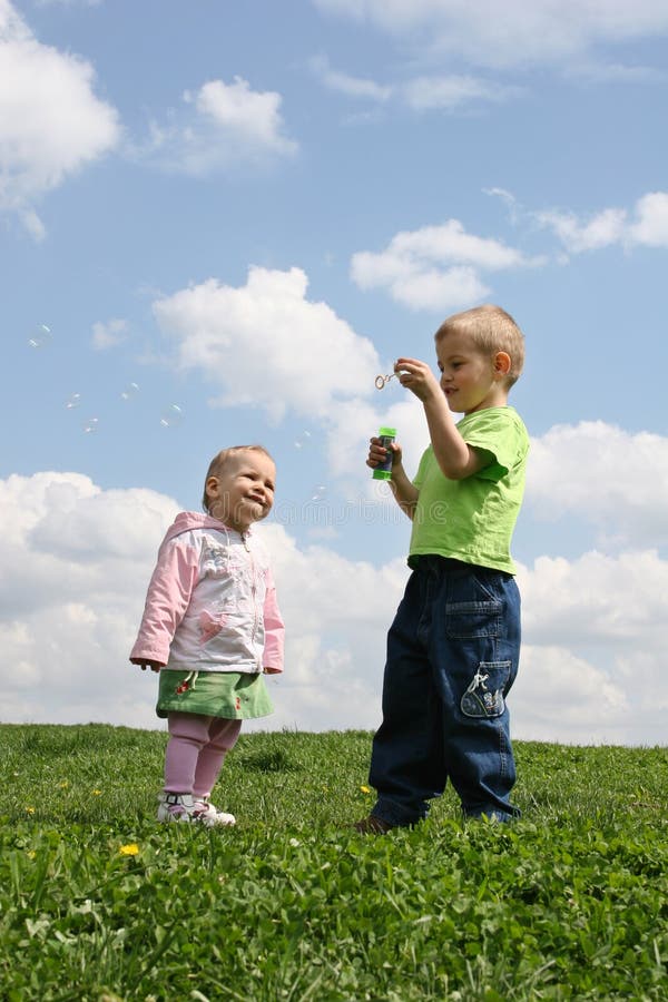 Children with soap bubbles on meadow. Children with soap bubbles on meadow