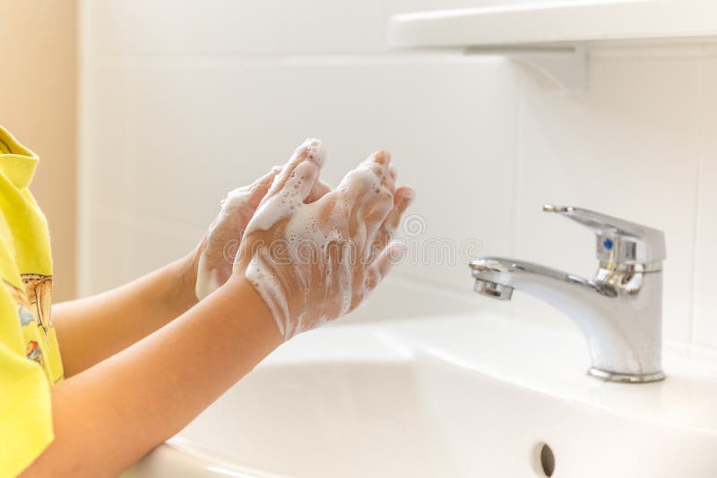 Bambini con le mani insaponate lavate nel lavandino del bagno