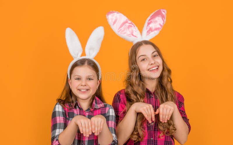 Bambini di Pasqua allegri e divertenti in orecchie conigliate su sfondo giallo fotografia stock