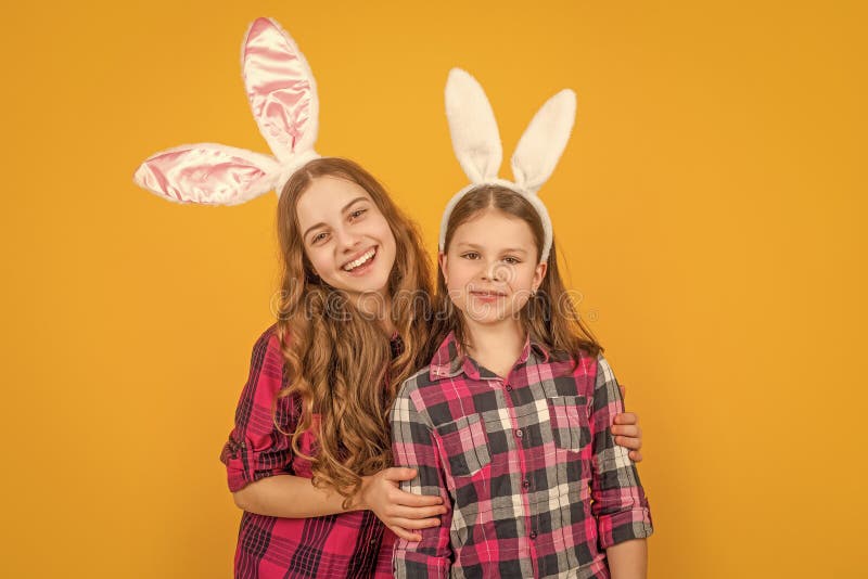 Bambini di Pasqua felici nelle orecchie di coniglio su sfondo giallo fotografie stock libere da diritti