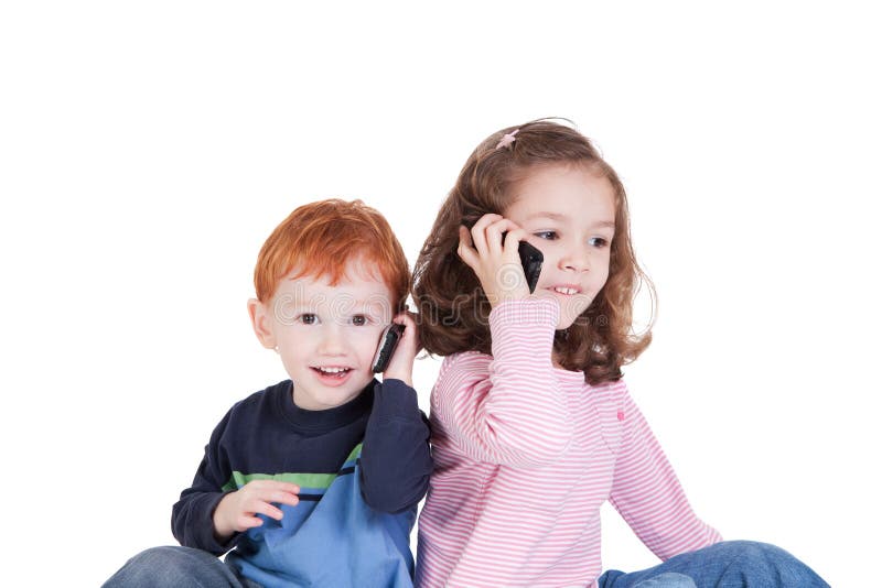 Bambini felici che comunicano sui telefoni mobili immagini stock Bambini felici che comunicano sui telefoni mobili immagini stock