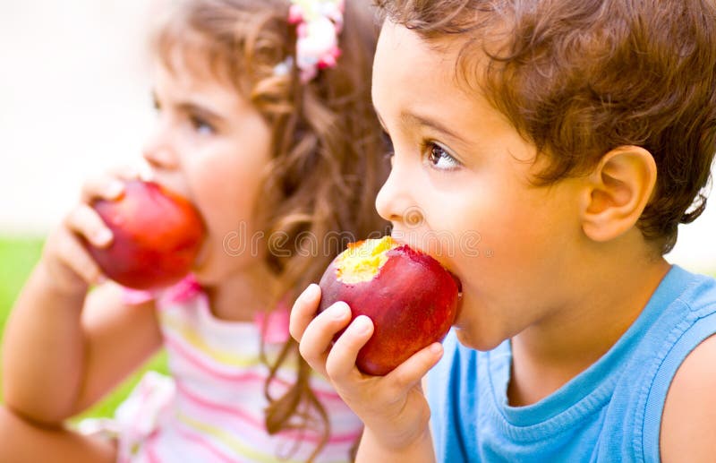 Bambini felici che mangiano mela