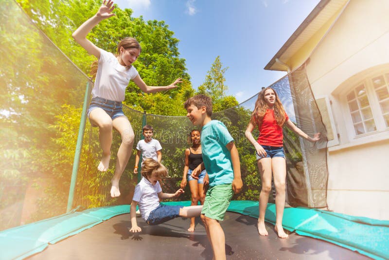 Bambini felici che saltano sul trampolino all'aperto fotografie stock Bambini felici che saltano sul trampolino all'aperto fotografie stock