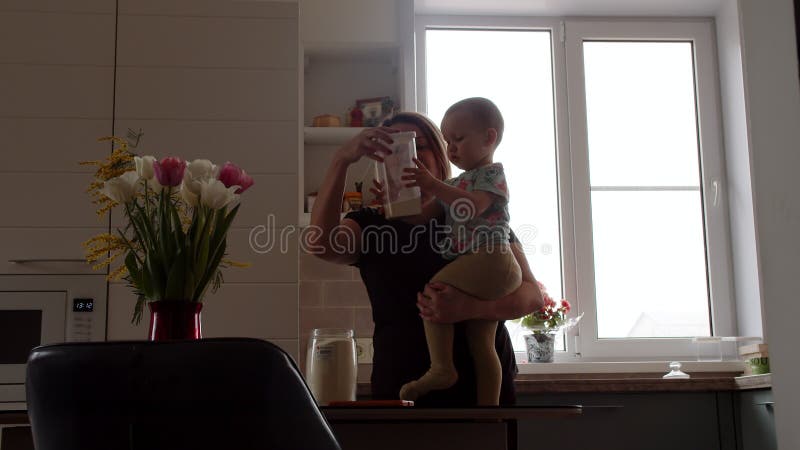 Bambini in maternità braccia aiuta a fare lavori domestici organizzazione spazio per la cucina