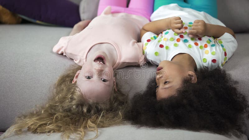 Bambini multi-etnici svegli che si trovano sullo strato e divertiresi, infanzia e feste fotografia stock Bambini multi-etnici svegli che si trovano sullo strato e divertiresi, infanzia e feste fotografia stock