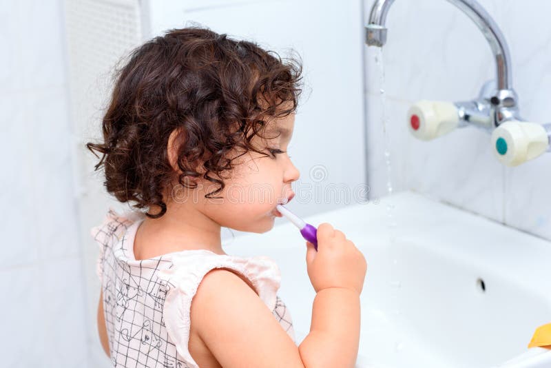 Bambini ricci del bambino che puliscono i denti Concetto sano del bambino L'igiene dentale del bambino fotografia stock libera da diritti Bambini ricci del bambino che puliscono i denti Concetto sano del bambino L'igiene dentale del bambino fotografia stock libera da diritti