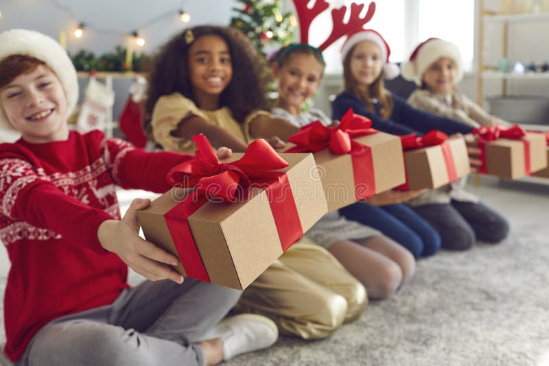 Bambini sorridenti con scatole da regalo e augurano a tutti buon Natale e felice anno nuovo fotografia stock