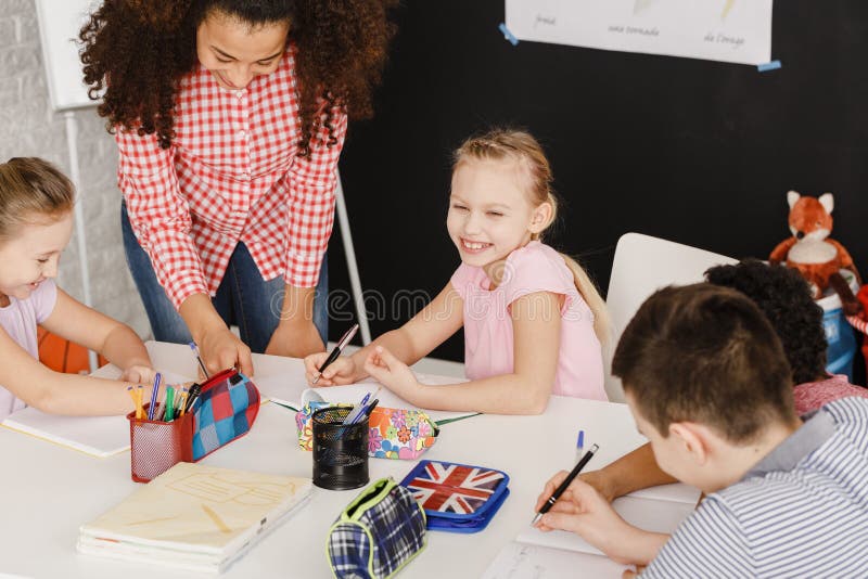 Bambini sorridenti ed insegnante femminile fotografie stock Bambini sorridenti ed insegnante femminile fotografie stock