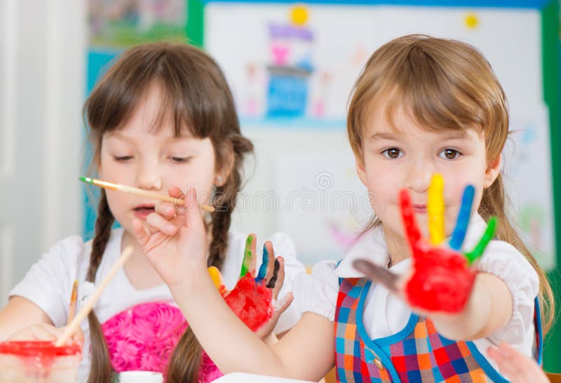 Bambini svegli che dipingono all'asilo fotografia stock Bambini svegli che dipingono all'asilo fotografia stock