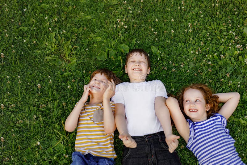 Bambini svegli che riposano sull'erba immagine stock Bambini svegli che riposano sull'erba immagine stock