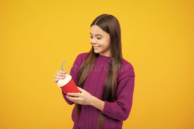 Bambino adolescente con tazza di caffè isolata su sfondo giallo da studio. Bevande portate via la bevanda. fotografia stock libera da diritti