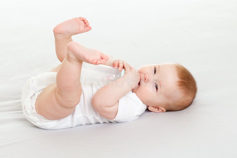 Bambino adorabile che beve dalla bottiglia immagini stock Bambino adorabile che beve dalla bottiglia immagini stock