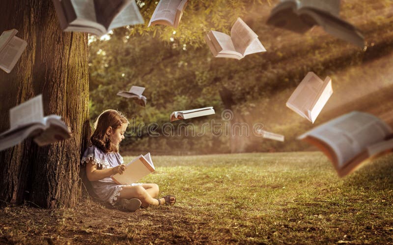 Bambino allegro che legge un libro interessante fotografia stock Bambino allegro che legge un libro interessante fotografia stock