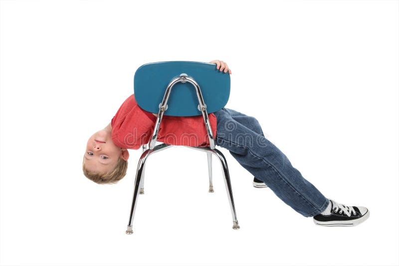Bambino annoiato che pone sulla presidenza immagine stock libera da diritti Bambino annoiato che pone sulla presidenza immagine stock libera da diritti