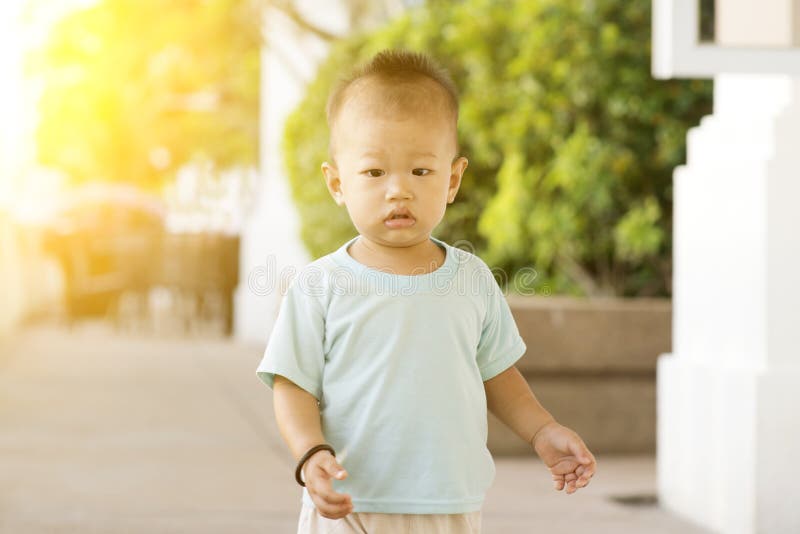 Bambino asiatico che cammina ad all'aperto fotografia stock libera da diritti Bambino asiatico che cammina ad all'aperto fotografia stock libera da diritti