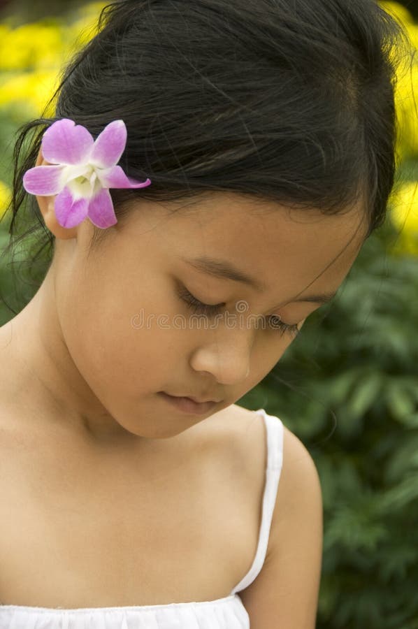 Bambino asiatico con il fiore in suoi capelli fotografie stock libere da diritti Bambino asiatico con il fiore in suoi capelli fotografie stock libere da diritti