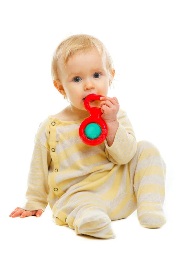 Bambino bello che gioca con il crepitio sul pavimento fotografie stock Bambino bello che gioca con il crepitio sul pavimento fotografie stock