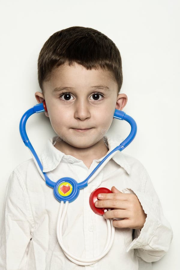 Bambino che ascolta il battito cardiaco con uno stetoscopio fotografia stock Bambino che ascolta il battito cardiaco con uno stetoscopio fotografia stock