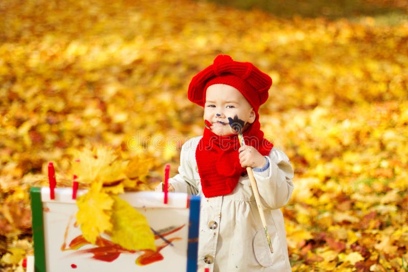 Bambino che attinge cavalletto in Autumn Park. Sviluppo creativo dei bambini fotografie stock Bambino che attinge cavalletto in Autumn Park. Sviluppo creativo dei bambini fotografie stock