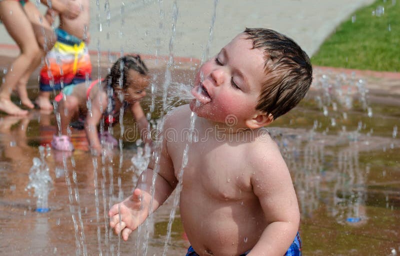 Bambino che beve in una fontana di estate fotografia stock libera da diritti Bambino che beve in una fontana di estate fotografia stock libera da diritti