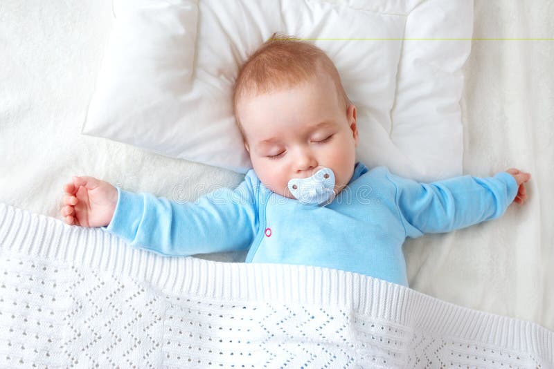 Bambino che dorme sulla coperta blu fotografie stock Bambino che dorme sulla coperta blu fotografie stock