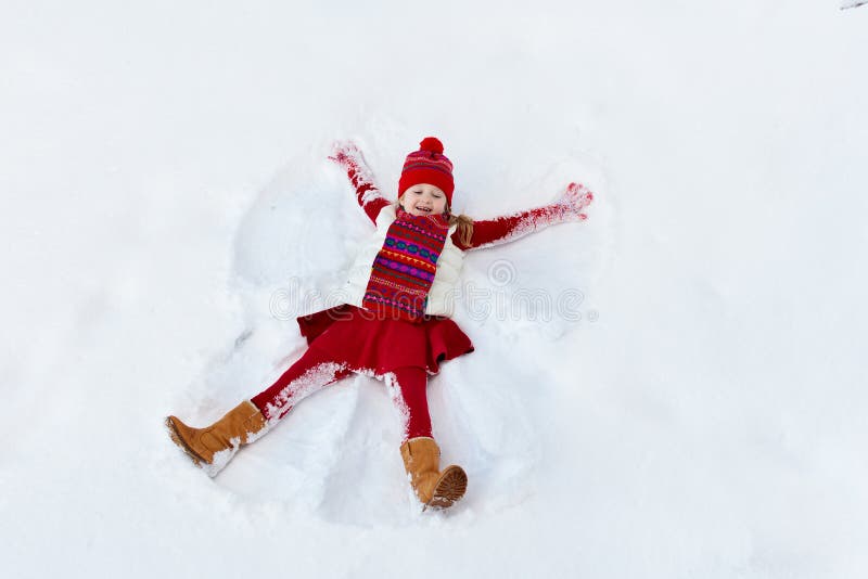 Bambino che fa angelo della neve sulla mattina soleggiata di inverno Divertimento all'aperto di inverno dei bambini Vacanza di Na immagini stock Bambino che fa angelo della neve sulla mattina soleggiata di inverno Divertimento all'aperto di inverno dei bambini Vacanza di Na immagini stock