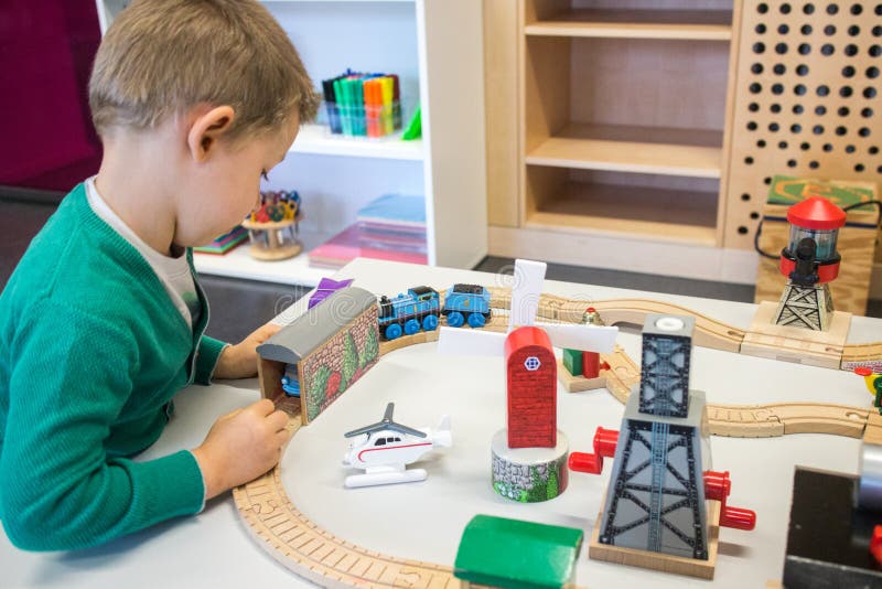 Bambino che gioca con il treno del giocattolo fotografie stock libere da diritti Bambino che gioca con il treno del giocattolo fotografie stock libere da diritti