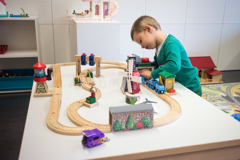 Bambino che gioca con il treno del giocattolo fotografia stock libera da diritti Bambino che gioca con il treno del giocattolo fotografia stock libera da diritti