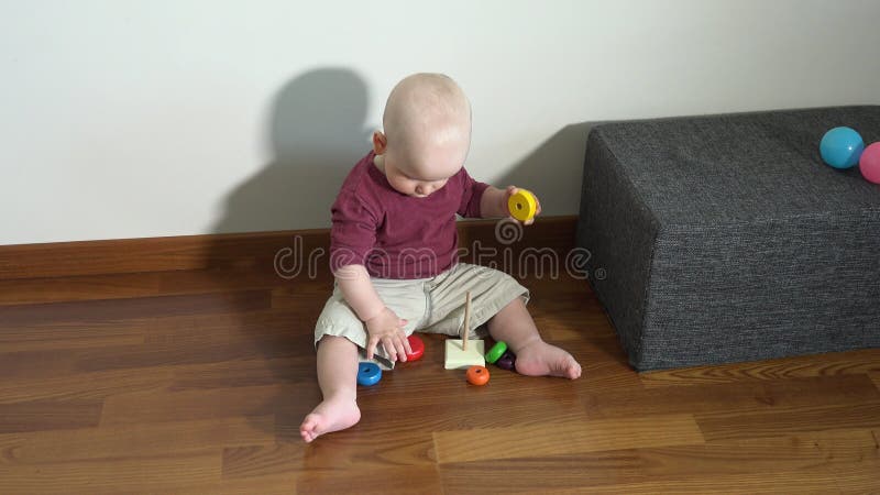Bambino che gioca a un gioco educativo con figure colorate di legno archivi video
