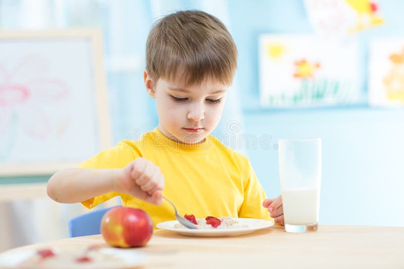 Bambino che mangia alimento sano a casa fotografia stock Bambino che mangia alimento sano a casa fotografia stock