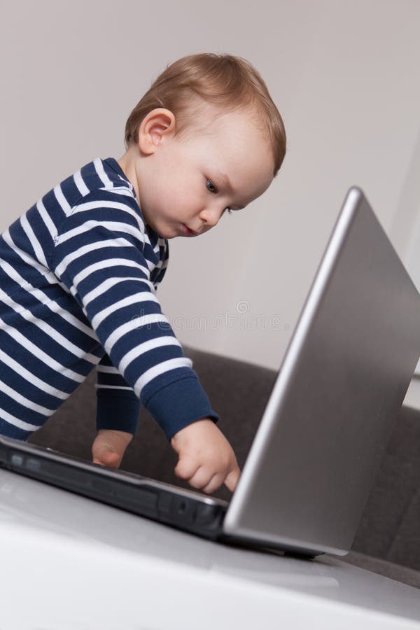 Bambino con il computer portatile fotografia stock Bambino con il computer portatile fotografia stock