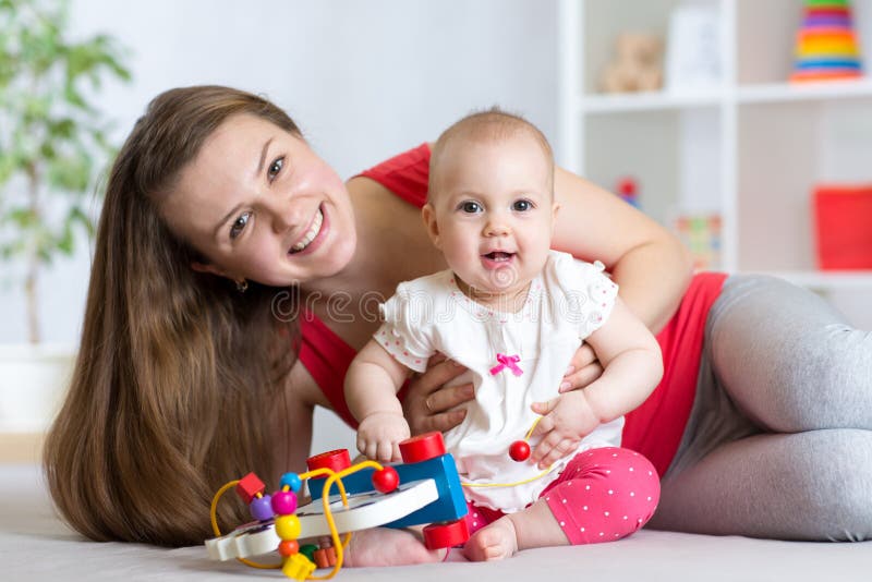 Bambino con la mamma Madre e figlia dell'interno Gioco della donna e della bambina insieme fotografia stock Bambino con la mamma Madre e figlia dell'interno Gioco della donna e della bambina insieme fotografia stock