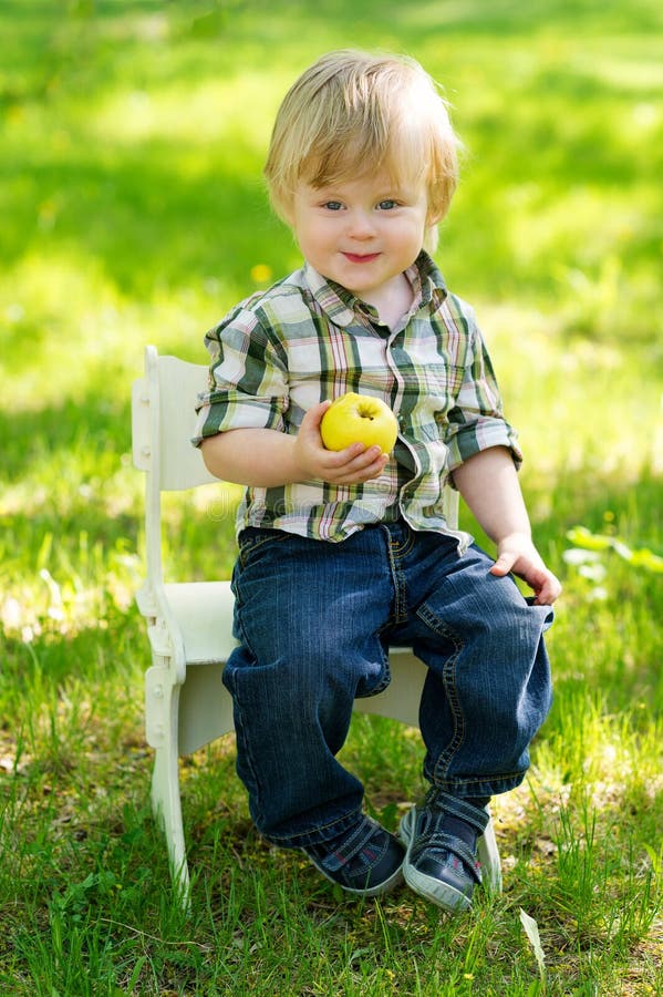 Bambino con la mela nel giardino fotografia stock Bambino con la mela nel giardino fotografia stock