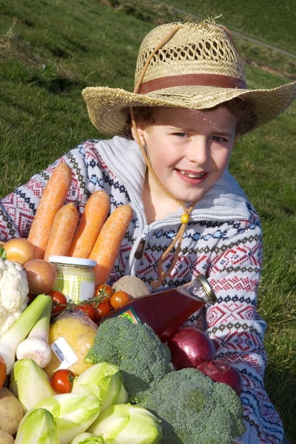 Boy (7) dressed as a farmer, holding a large basket with vegetables. Boy (7) dressed as a farmer, holding a large basket with vegetables