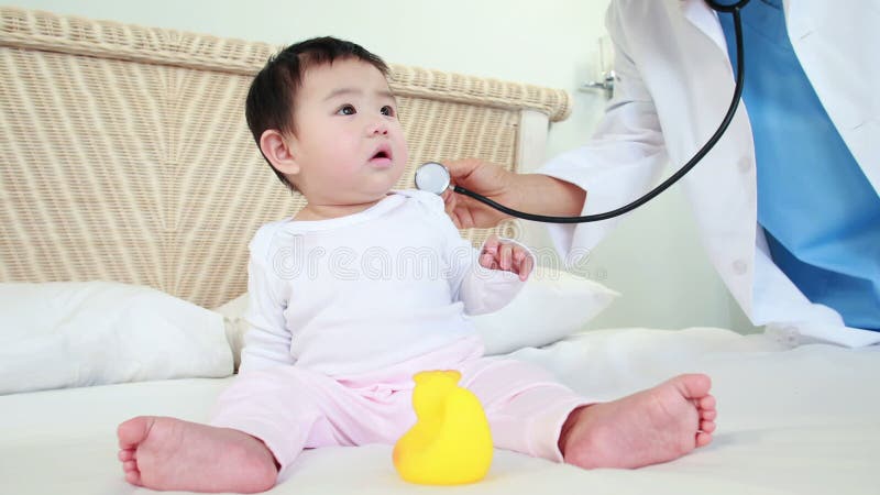 Bambino d'esame di medico sul letto