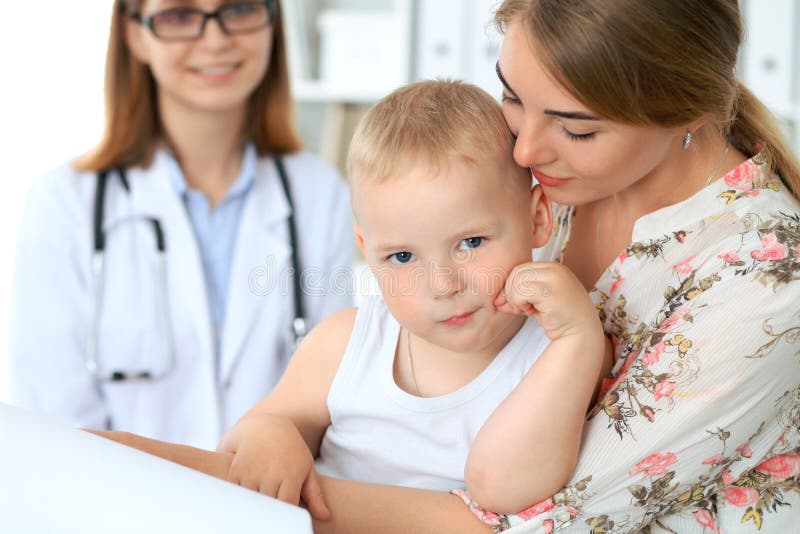 Bambino del ragazzino con sua madre dopo l'esame di salute all'ufficio del ` s di medico fotografia stock libera da diritti Bambino del ragazzino con sua madre dopo l'esame di salute all'ufficio del ` s di medico fotografia stock libera da diritti