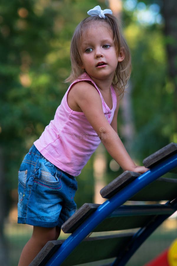 Bambino della ragazza nel campo da giuoco fotografia stock libera da diritti Bambino della ragazza nel campo da giuoco fotografia stock libera da diritti