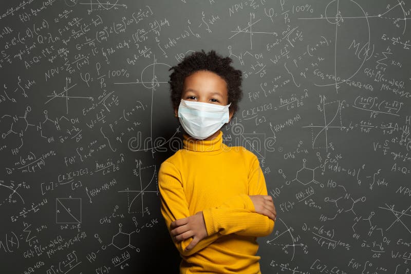 Bambino di colore di successo, un bambino di colore, con maschera protettiva sul fondo della lavagna nera immagine stock