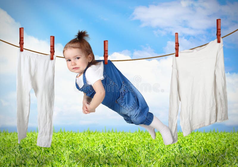 Bambino divertente che appende sulla linea con i vestiti, conce creativo della lavanderia immagini stock libere da diritti Bambino divertente che appende sulla linea con i vestiti, conce creativo della lavanderia immagini stock libere da diritti