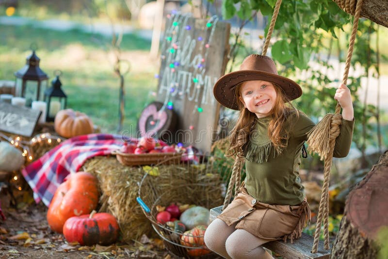 Bambino divertente del bambino della ragazza nel gioco del costume di verde di Halloween all'aperto con le zucche spettrali della fotografia stock Bambino divertente del bambino della ragazza nel gioco del costume di verde di Halloween all'aperto con le zucche spettrali della fotografia stock