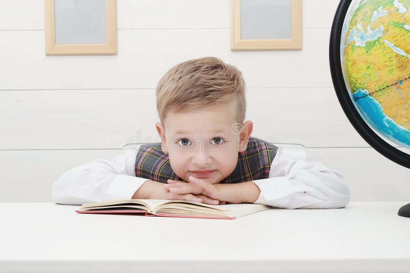 Bambino divertente a scuola ragazzino con il libro, istruzione dei bambini immagini stock Bambino divertente a scuola ragazzino con il libro, istruzione dei bambini immagini stock