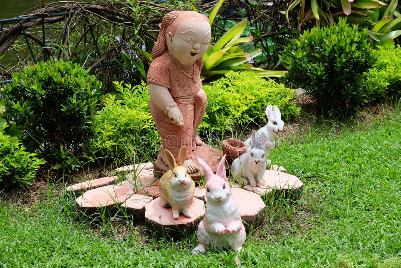 Bambino e conigli di sorriso in un giardino o in un parco immagine stock libera da diritti
