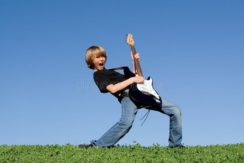 Bambino felice che gioca chitarra fotografia stock libera da diritti Bambino felice che gioca chitarra fotografia stock libera da diritti